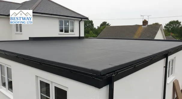 A slightly elevated wide-angle view of a large, new black EPDM rubber flat roof on a modern extension, helping homeowners understand how much does a new roof cost when choosing a seamless, single-piece membrane.
