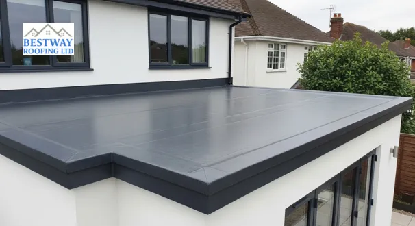 Elevated view of a modern UK home extension featuring a seamless, charcoal grey GRP fibreglass roof, showcasing premium Flat Roof Materials with a flawless, weather-resistant finish.