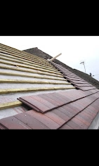 Fixing a roof with new wooden laths and red tiles.