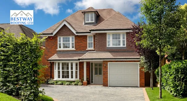 A modern two-story detached red-brick house featuring a complex roofline with multiple gables, white window frames, an integrated garage, and visible black guttering and downpipes.
