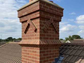 Newly repaired red brick chimney stack featuring decorative masonry work and brand new clay pots in Chelmsford.